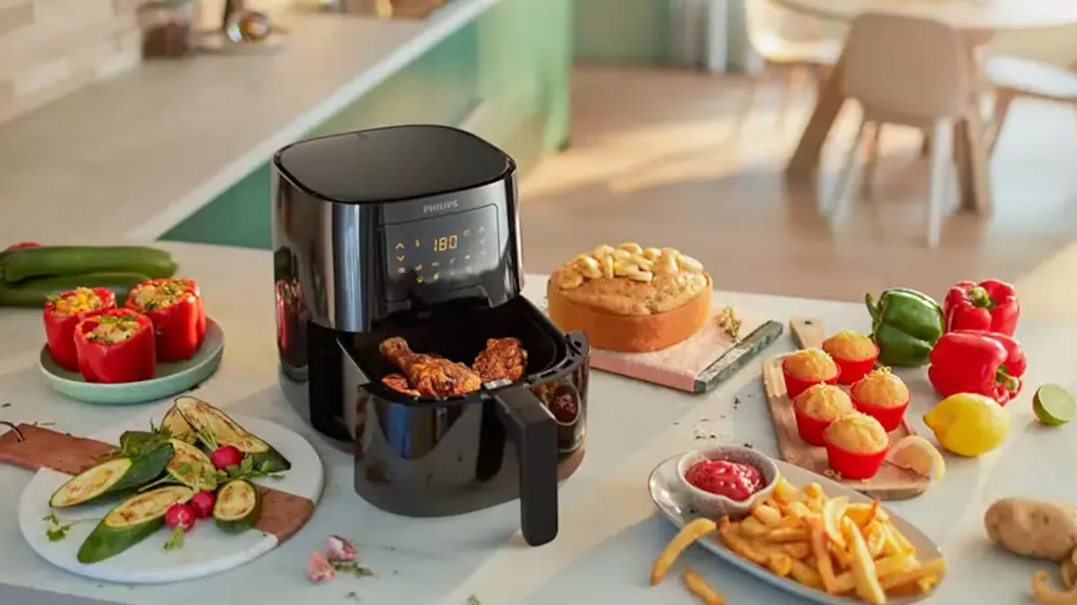 Friteuse sans huile noire posée sur un plan de travail en bois dans une cuisine claire